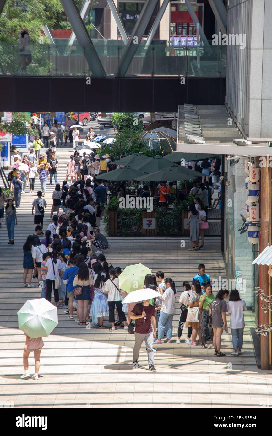 Chinese fans wait in a long queue in front of a milk tea store operated ...