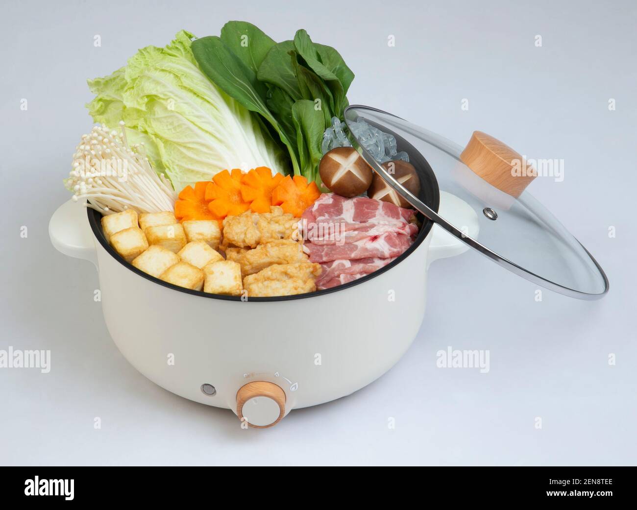 Electric pot and cover with vegetable and meat isolated on white background Stock Photo