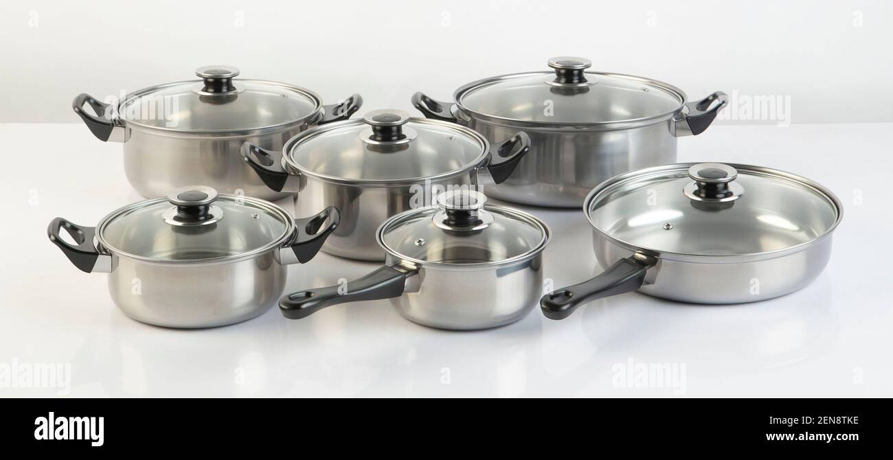 Set of stainless pots with lids isolated on white background Stock Photo