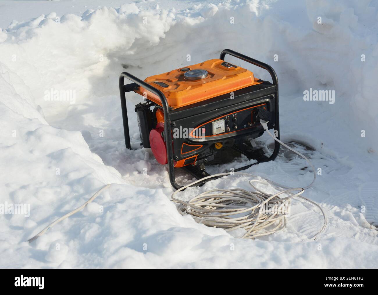 Usage of gasoline portable outdoor generator, home power generator to backup the house during blackouts, outages as a result of a winter storm. Stock Photo
