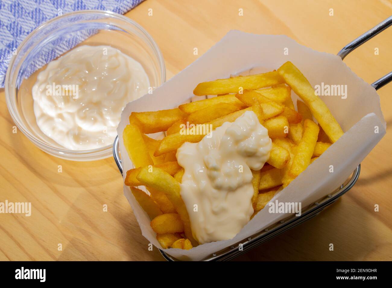 french fries in a metal basket and home made mayonnaise in a glass bowl Stock Photo