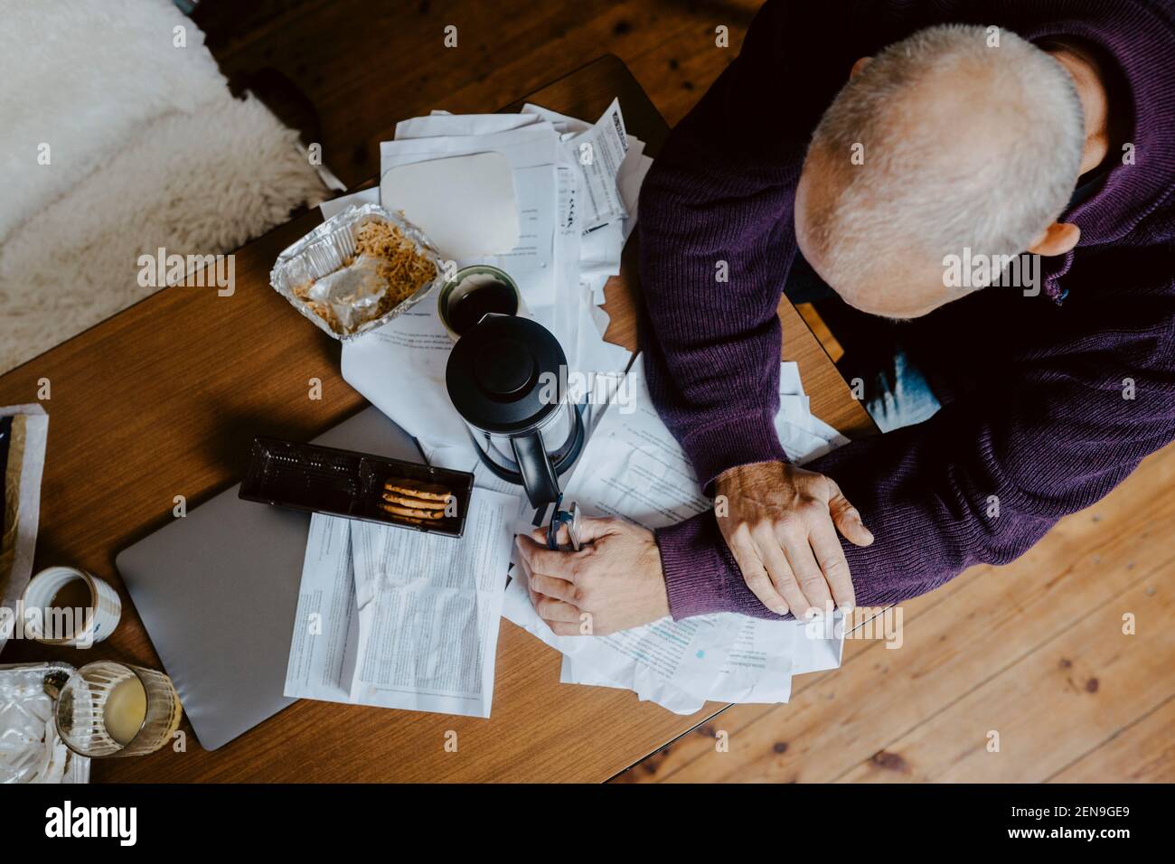 Directly above shot of businessman with document on table at home Stock Photo