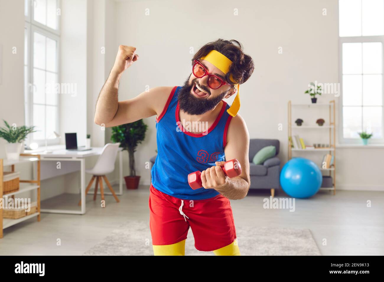 Crazy sports trainer holding dumbbell and clenching fist motivating you to exercise Stock Photo