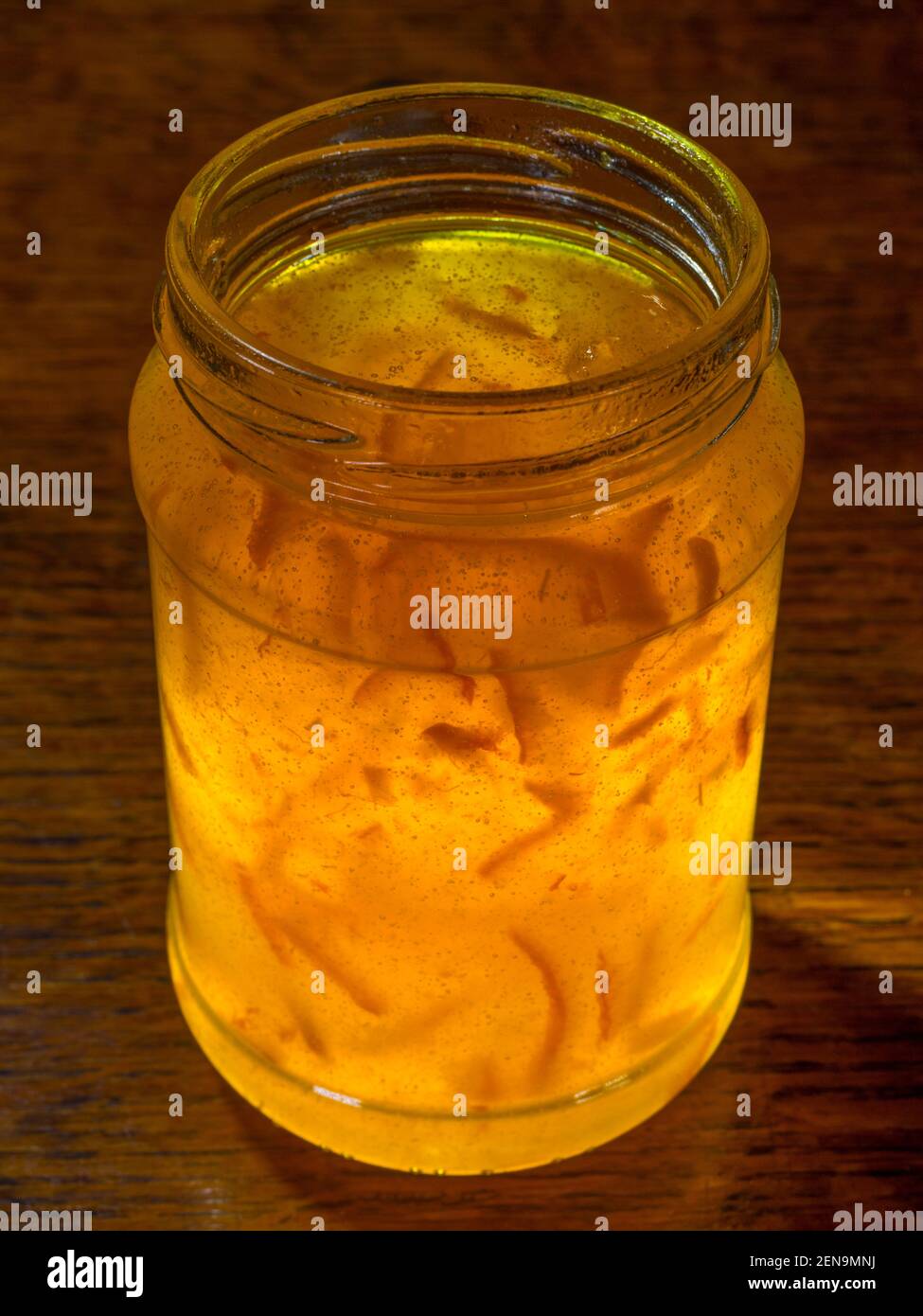 Closeup of a newly opened jar of unbranded, traditional Seville, orange fruit and peel marmalade preserve, with the lid removed. Stock Photo