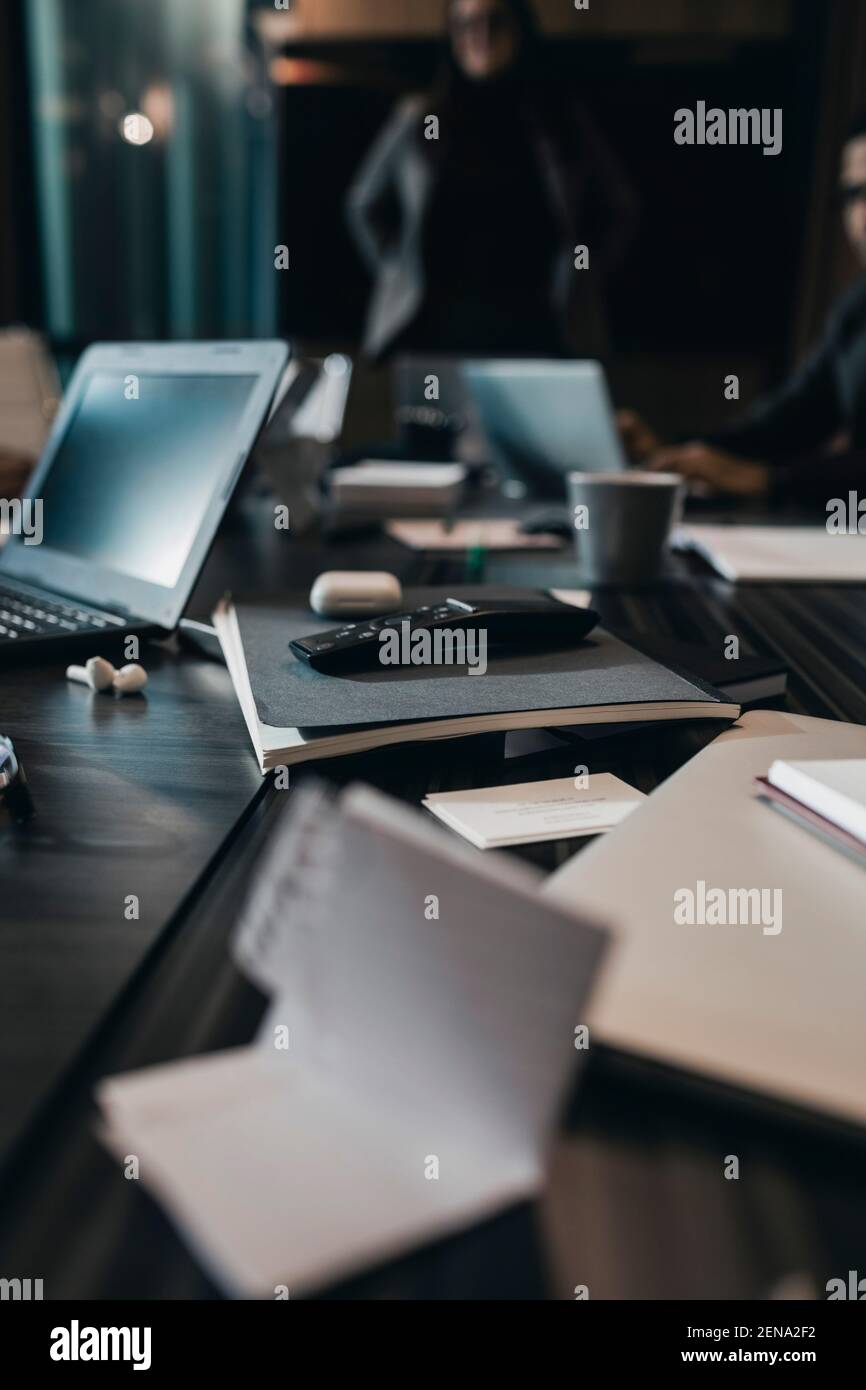 Remote control on book at conference table in office board room Stock Photo