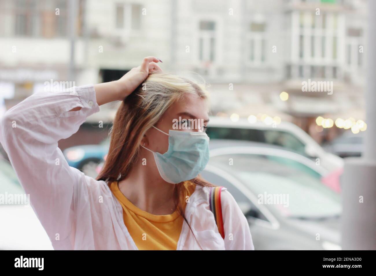 girl teenager in a protective mask on a blurred background of the cityscape Stock Photo