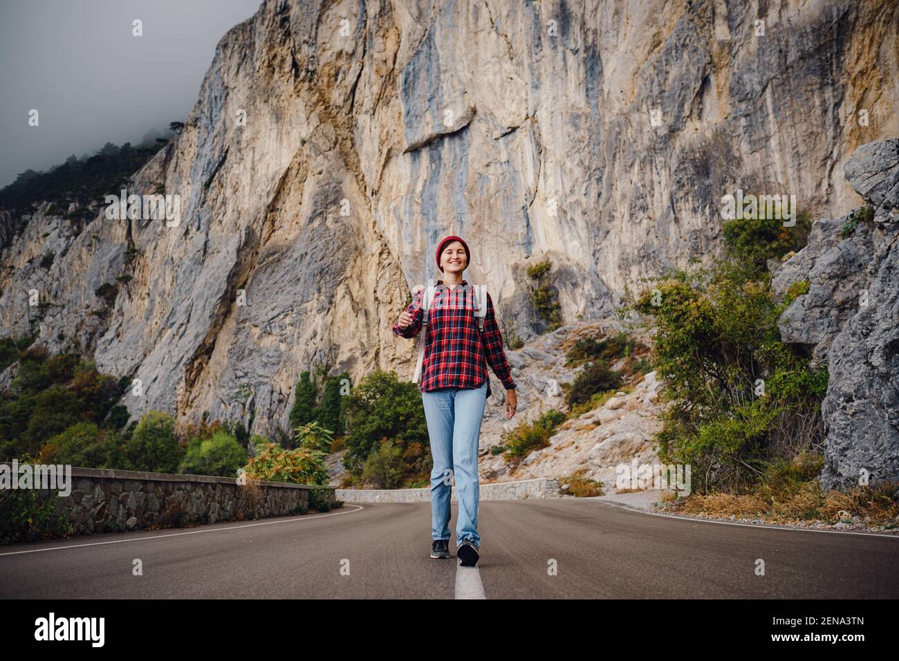 Asian hipster woman walking alone on a mountain highway on an autumn ... - Solo Travel Digital Detox
