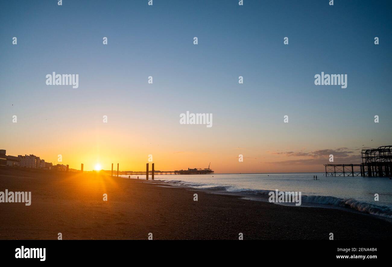 Brighton UK 26th February 2021 - Early birds catch the spectacular sunrise in Brighton this morning as sunny weather is forecast for the next few days : Credit Simon Dack / Alamy Live News Stock Photo