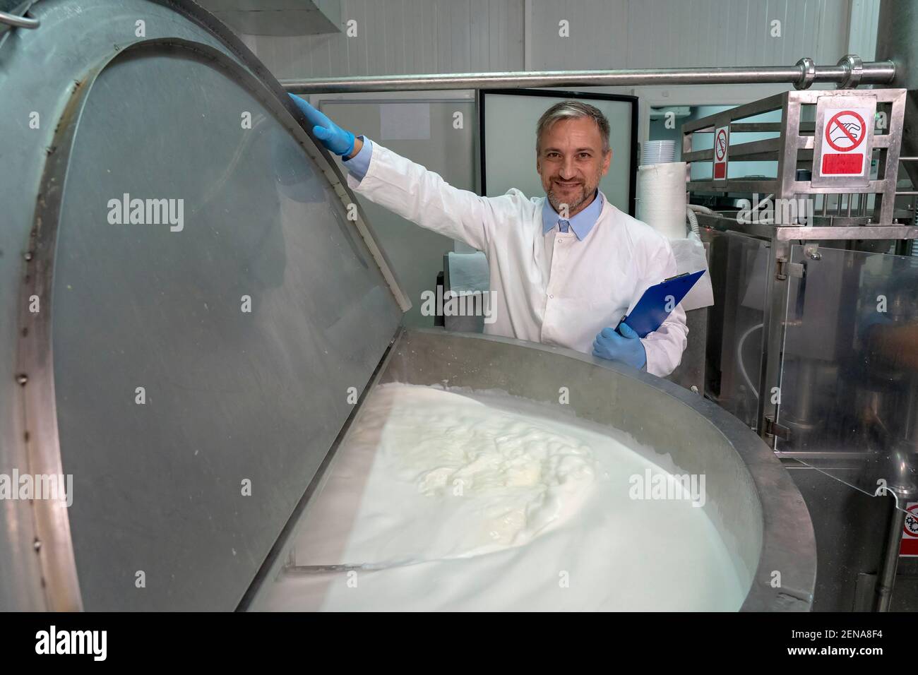 Portrait of Food Engineer in Dairy Plant. Milk Pasteurization in Dairy Processing Plant. Milk inside the Pasteurization Tank. Dairy Plant Food Safety. Stock Photo