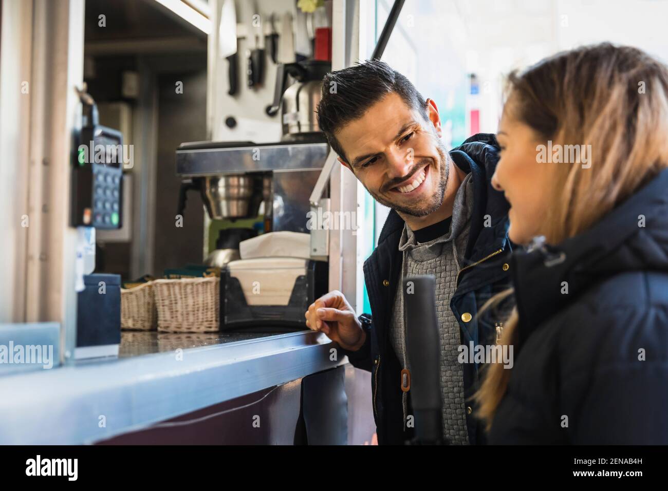 Smiling couple talking with each other at food truck Stock Photo