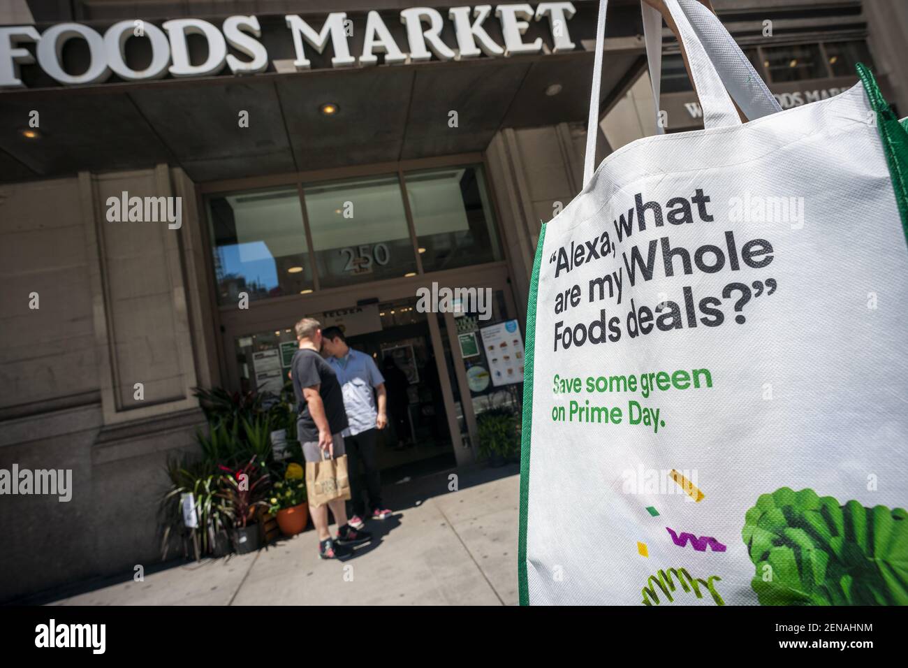 An Amazon Prime Member with her souvenir shopping bag passes Whole Foods  Market in Chelsea in New York on Amazon's self-proclaimed "Prime Day"  holiday Monday, July 15, 2019. This is the fifth year that Amazon is  offering bargains and deals galore ...