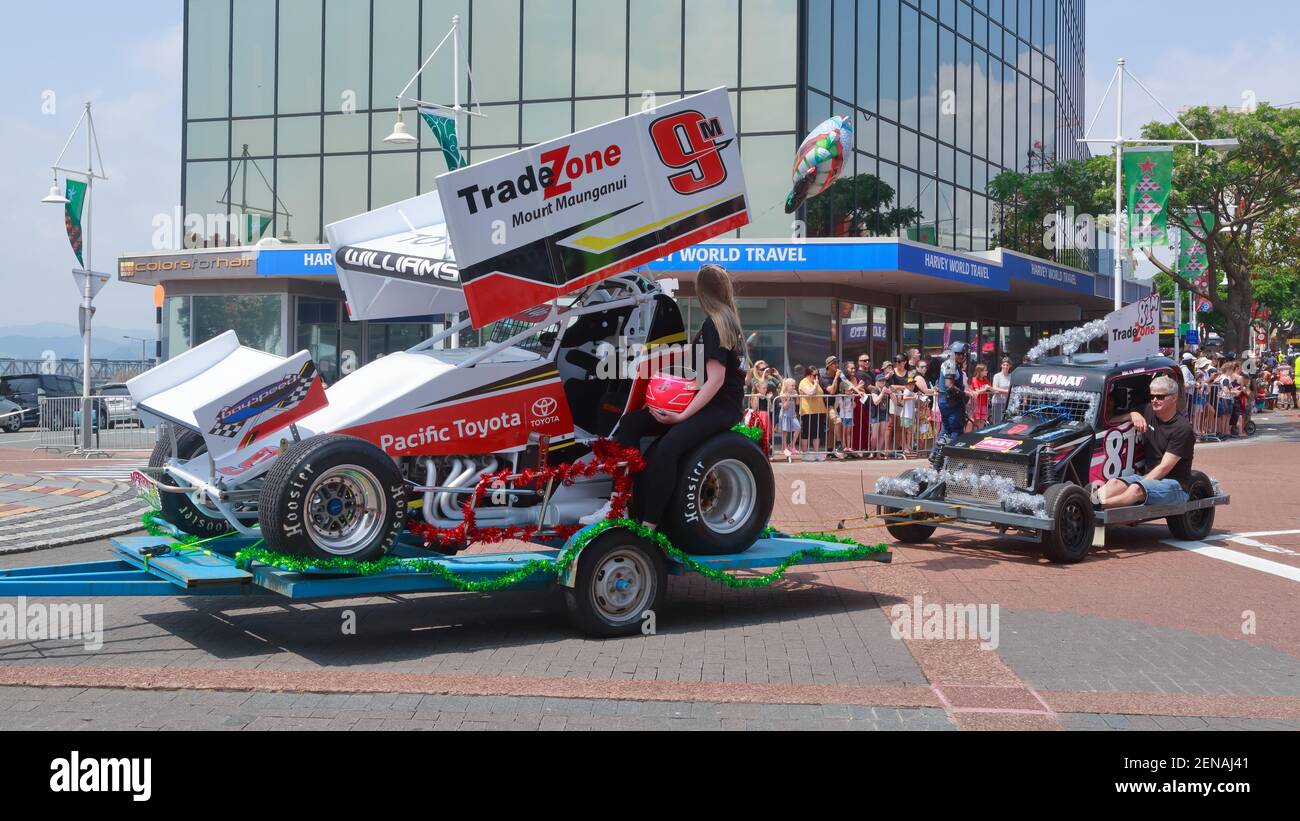 Sprint cars on trailers, decorated with tinsel, taking part in a Christmas parade. Tauranga, New Zealand Stock Photo