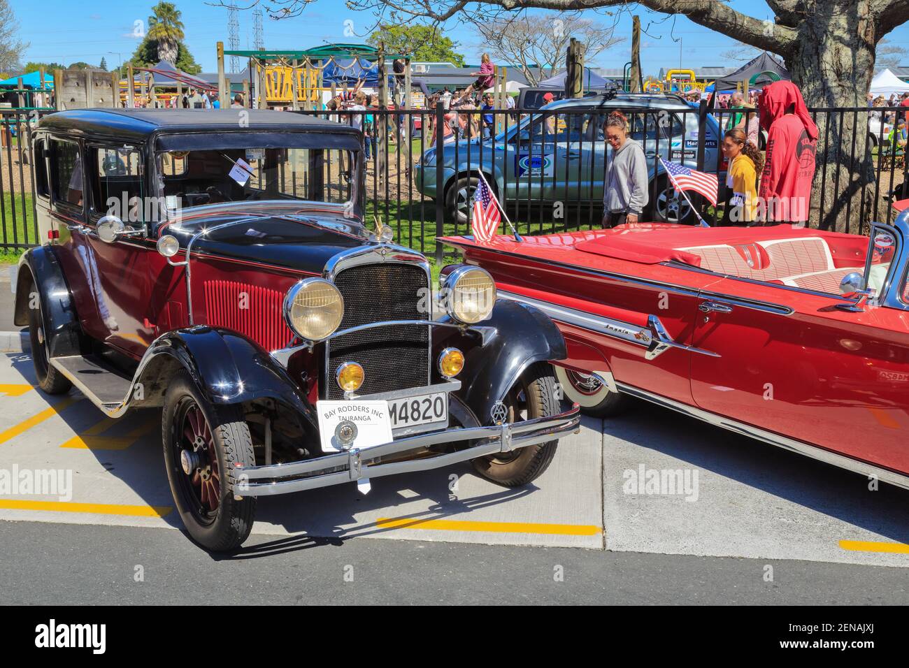 A 1929 Dodge 4-Door Sedan at a classic car show. Next to it is a red 1960 Chevrolet Impala Stock Photo