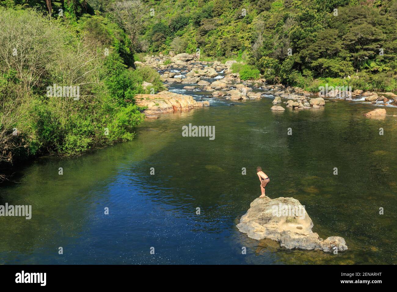 A rocky river cascading out of forested hills into a swimming hole in the Karangahake Gorge, New Zealand Stock Photo