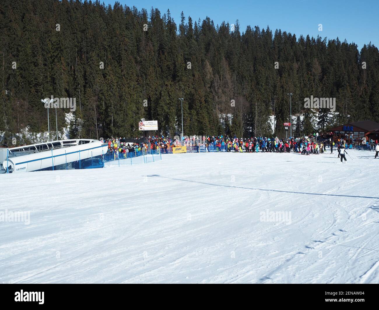 Białka Tatrzańska, Poland - February 23, 2021: A long que of skiers and snowboarders to the ski lift during a sunny weather Stock Photo