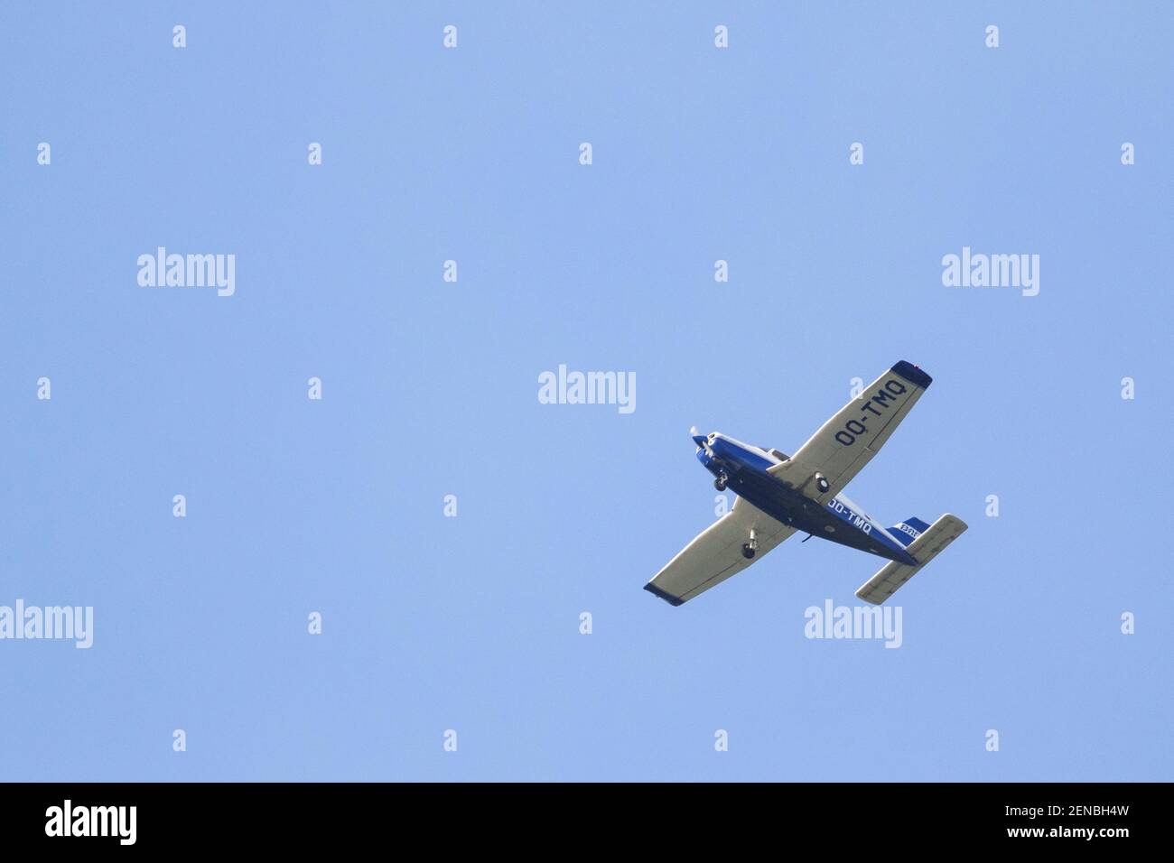 A portrait of a sport plane flying through a blue sky. The small airplane, aircraft is flying straight through the air with its wings level to the gro Stock Photo