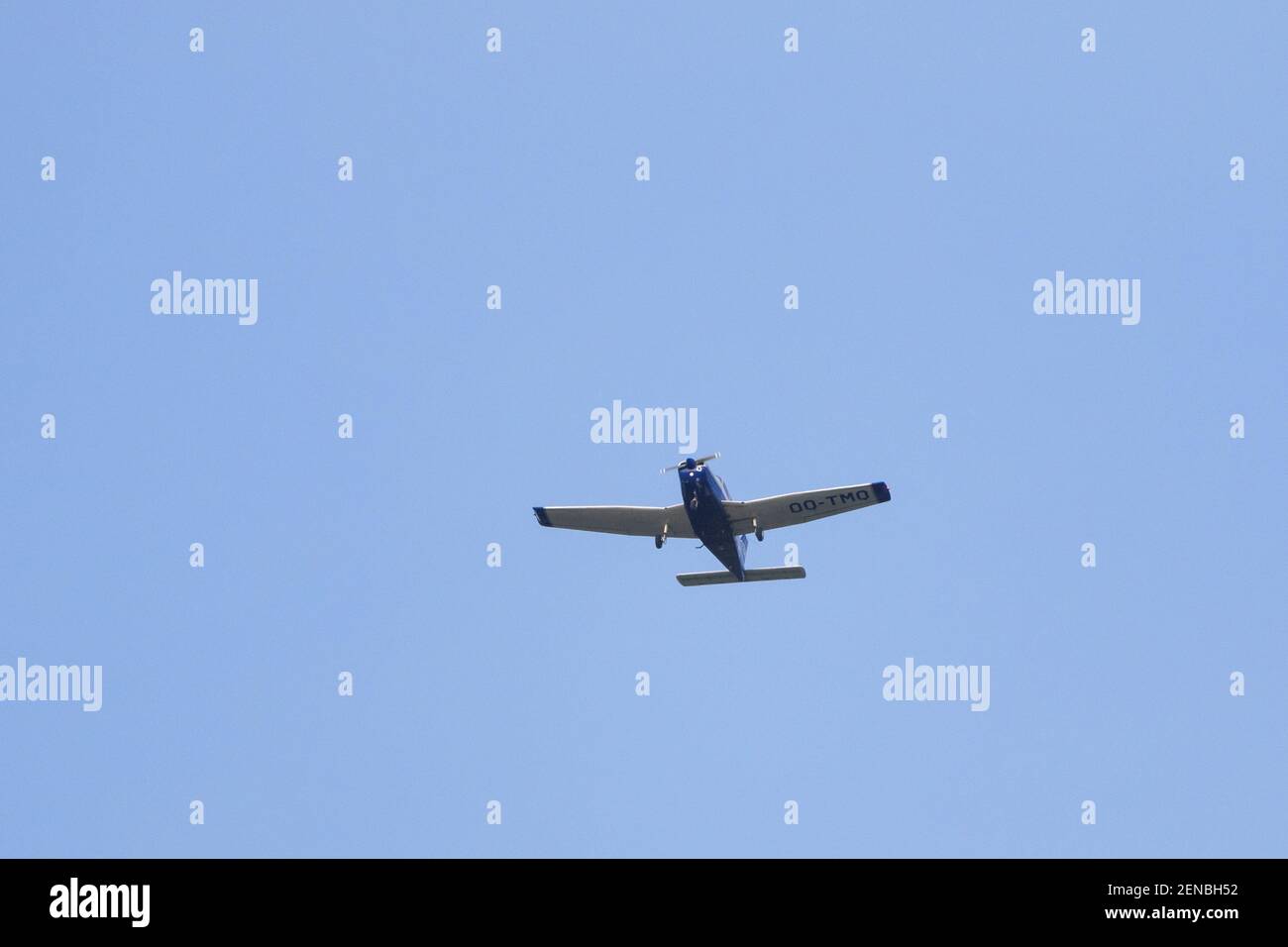A portrait of a sport airplane flying through a blue sky. The small plane, aircraft is flying straight through the air with its wings level to the gro Stock Photo