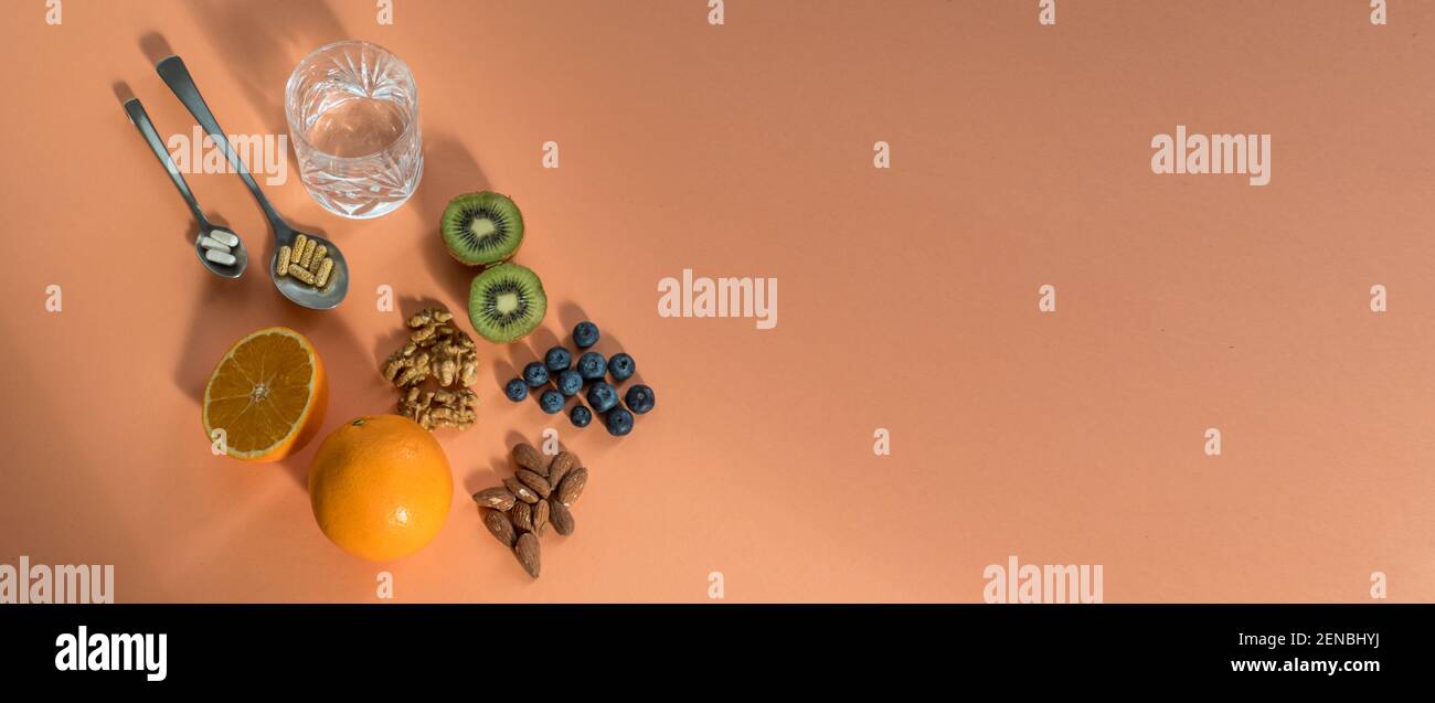 Comparison of fresh healthy fruits and food supplements Stock Photo