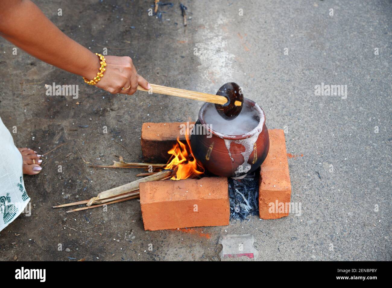 Women preparing a divine food made of rice in earthen pots and offer it to the Attukal Amma (Goddess of the Temple) during attukal pongala. Kerala Stock Photo