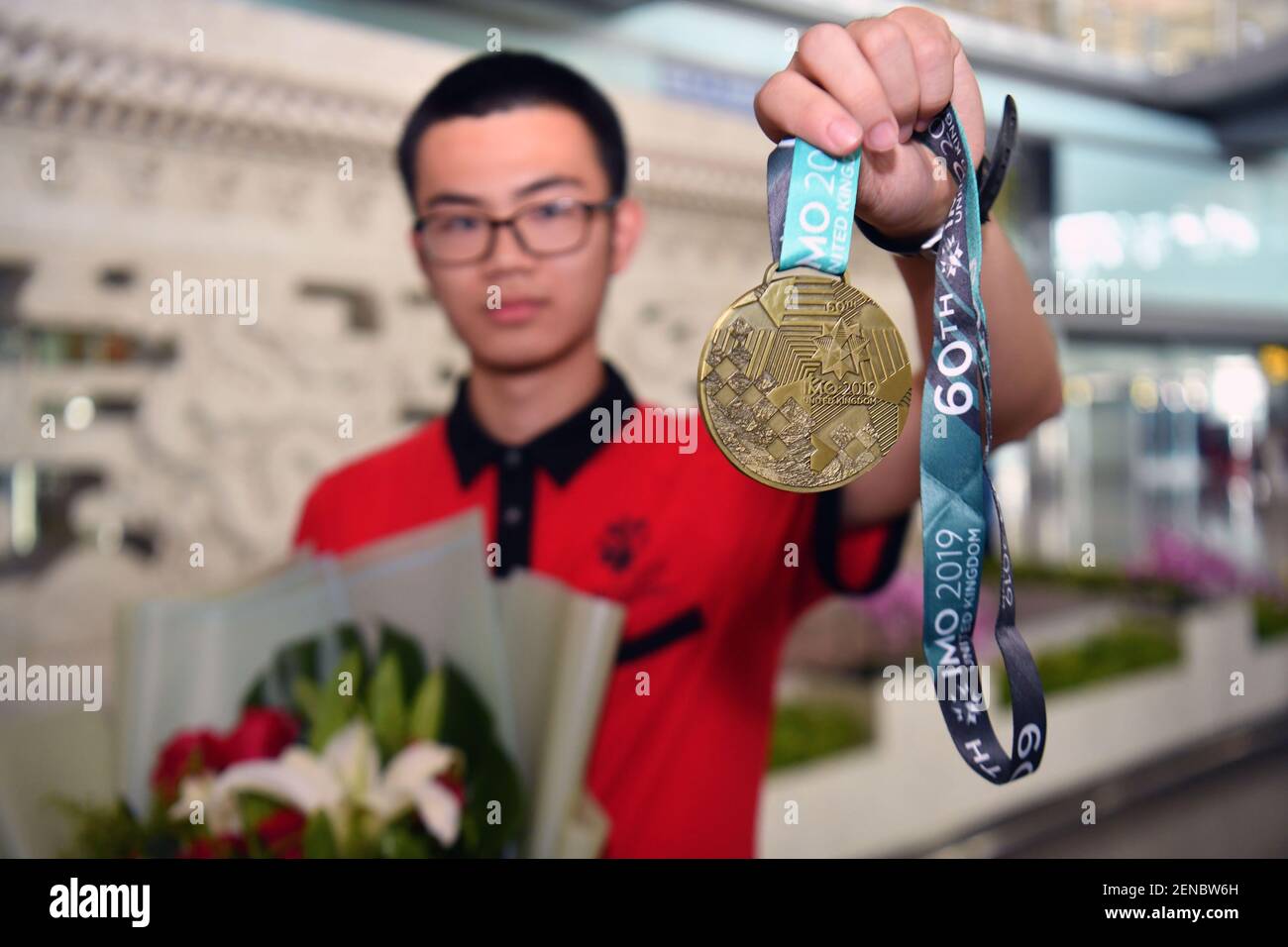A high-school student from team China shows his gold medal at the ...
