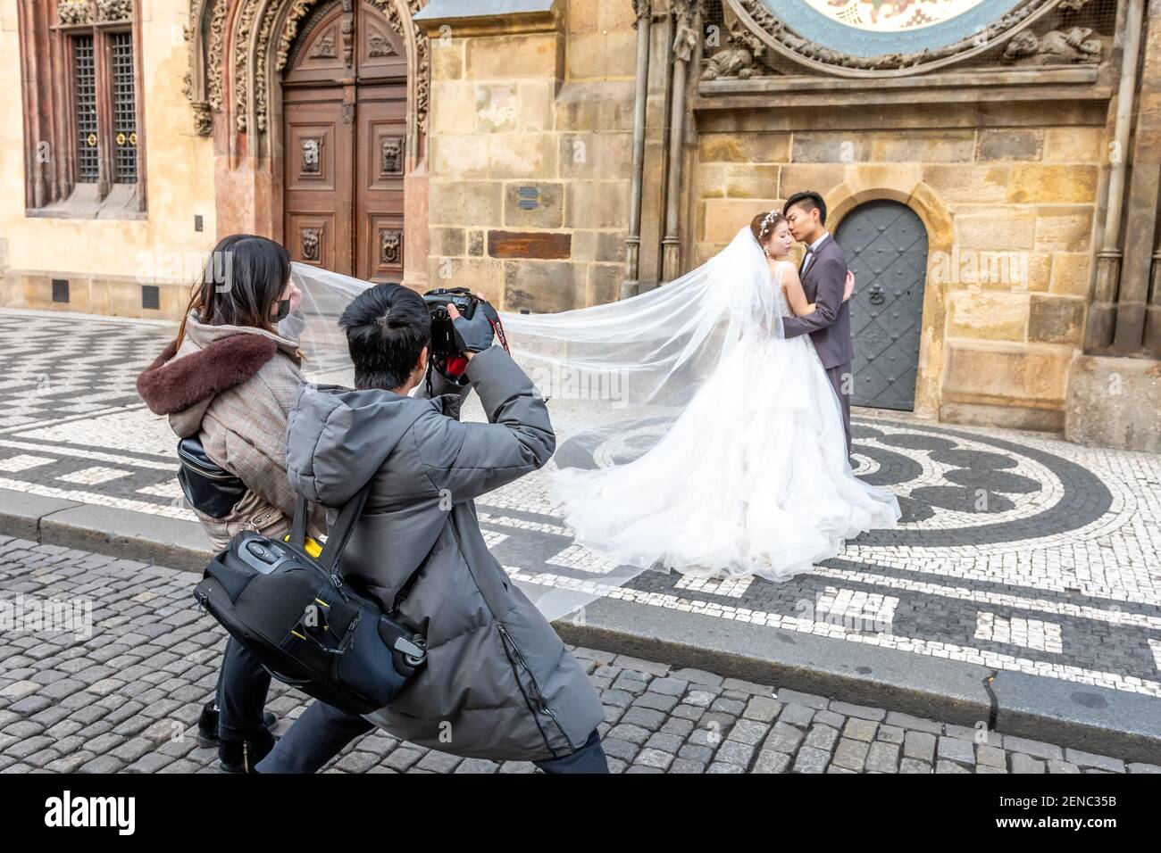 Prague, Czech Republic -January 20, 2020: Chinese photographer takes pictures of a wedding couple. Stock Photo