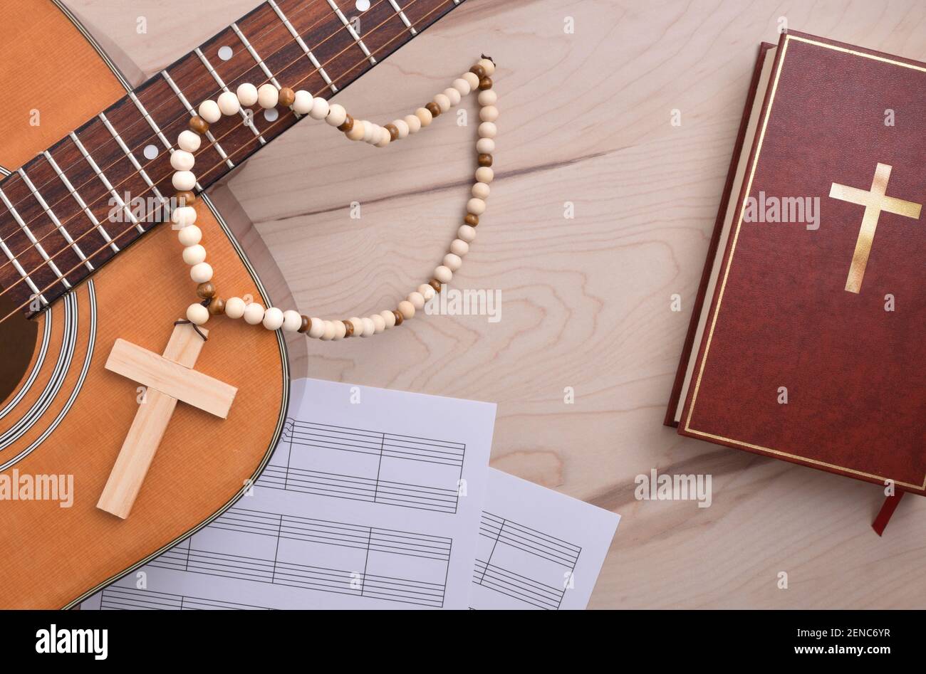 Christian music with table with guitar cross bible and sheet music close up. Top view. Horizontal composition. Stock Photo