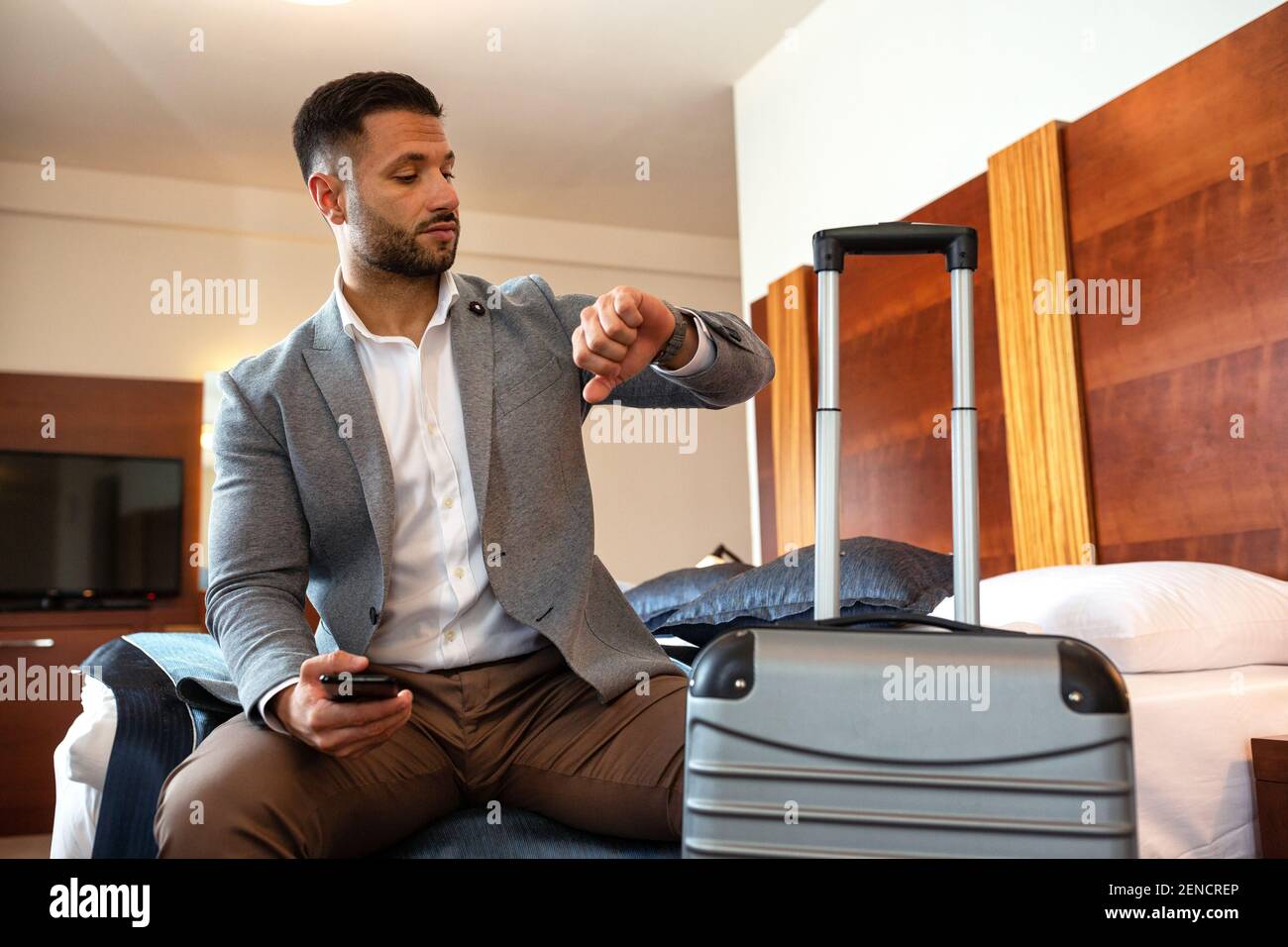Businessman looking on his watch while sitting down Stock Photo