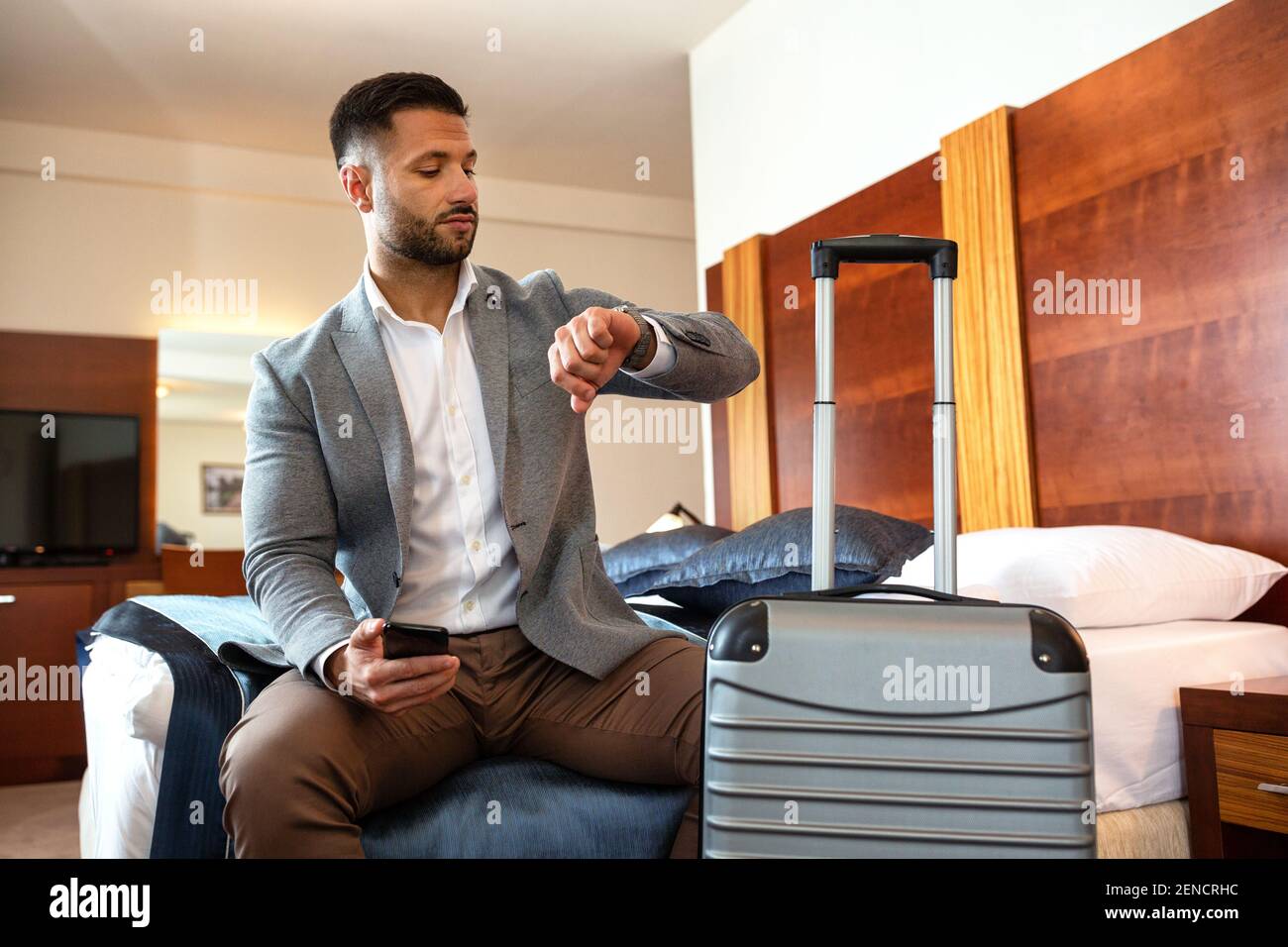 Businessman looking on his watch while sitting down Stock Photo