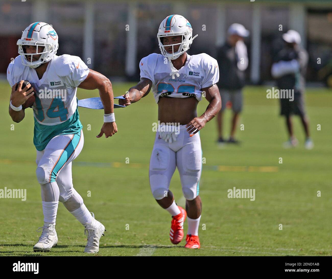 Running back Kenneth Farrow, left, runs with the ball using a ...