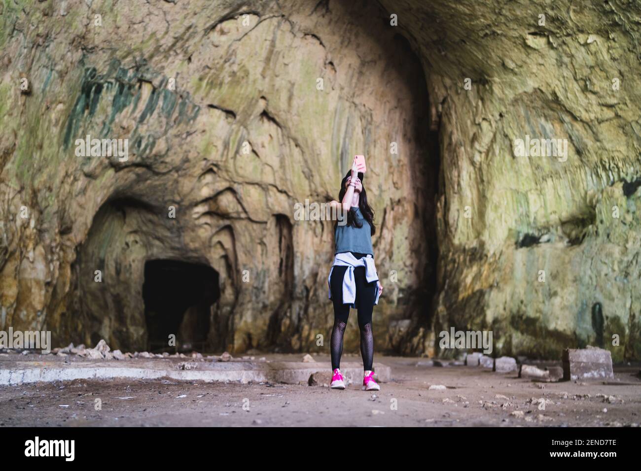 Girl make photo with smartphone in font of devetashka cave near lovech  Stock Photo