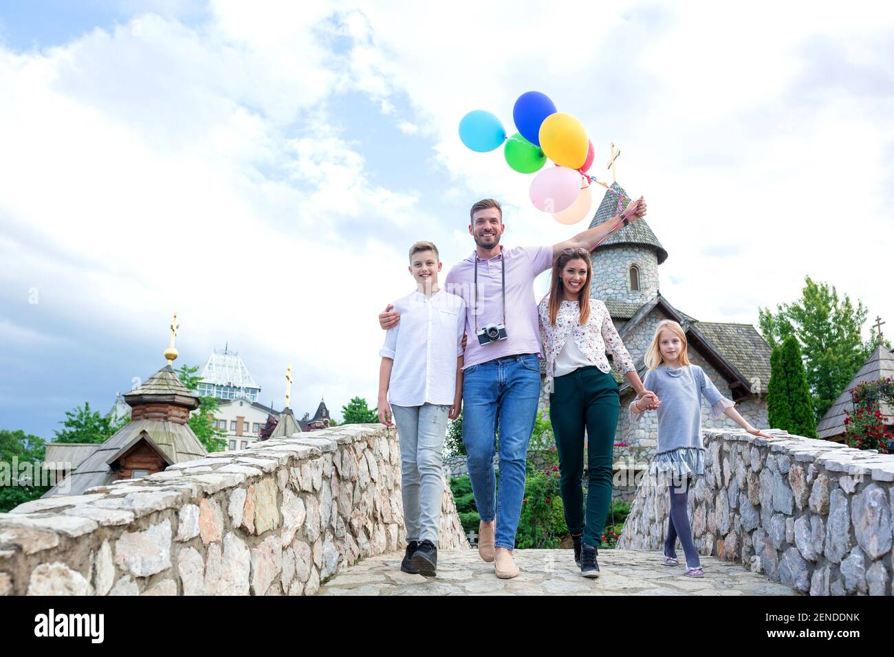 Mom, dad and their happy kids on the stone bridge, happy family time ...