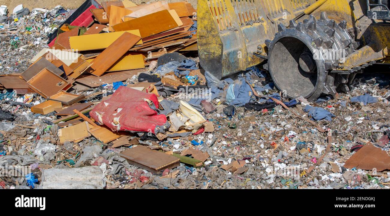 Close up of bulldozer working on the huge household garbage landfil, ecologic problem, environmental impact Stock Photo