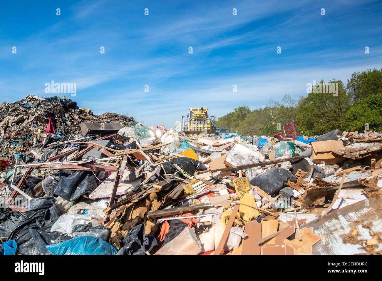 Close up of bulldozer working on the huge household garbage landfil, ecologic problem, environmental impact Stock Photo