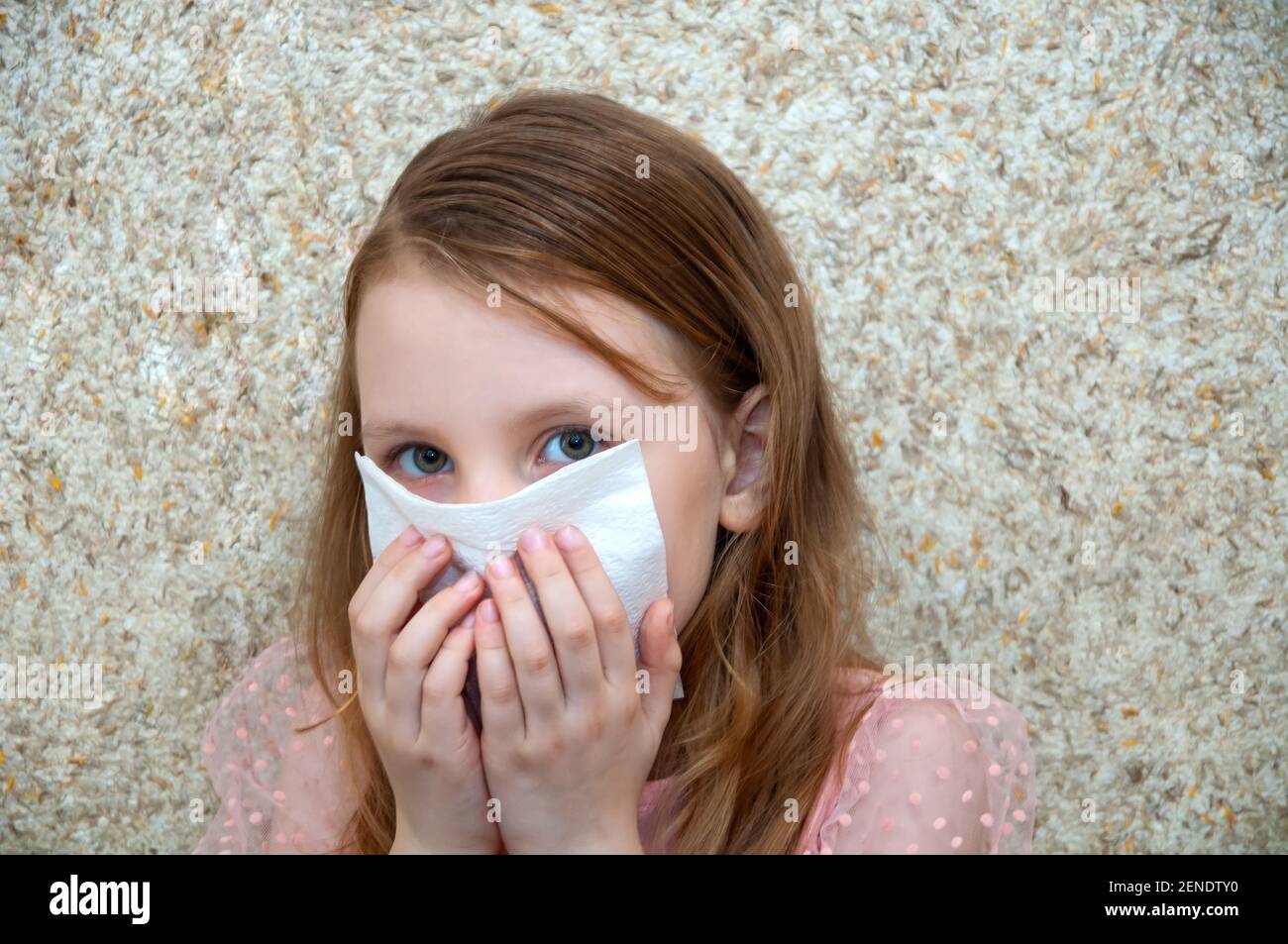Child girl with a cold virus wipes his nose from a runny nose Stock Photo