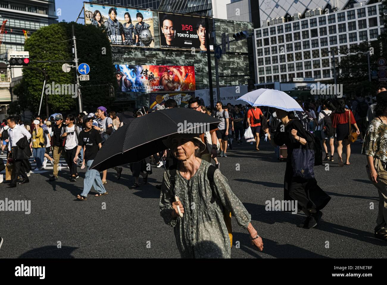 People hold umbrellas at the Shibuya crossing in Tokyo. A deadly heat ...