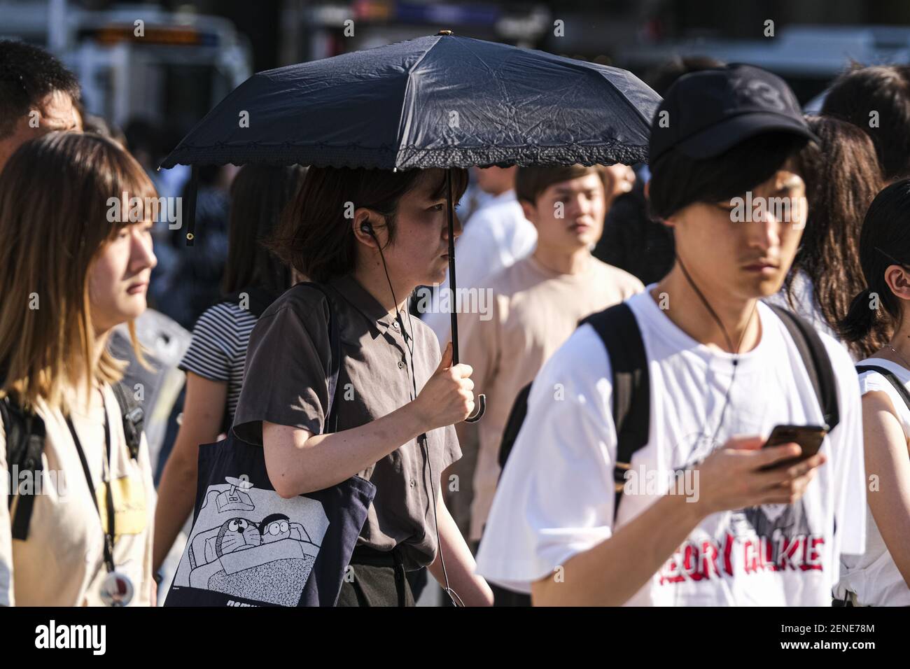 A woman holds an umbrella at the Shibuya crossing in Tokyo. A deadly ...