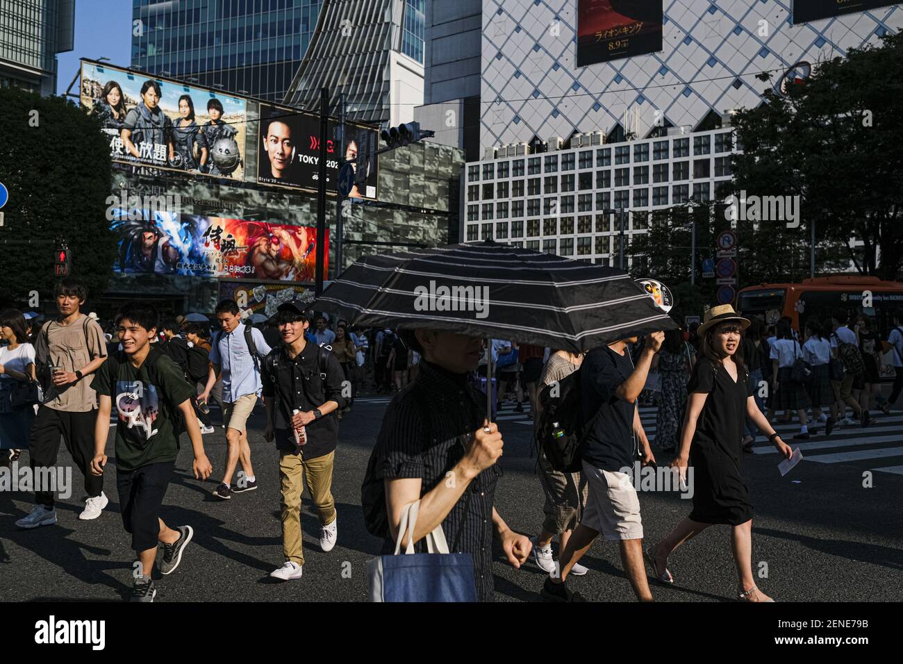 A woman holds an umbrella at the Shibuya crossing in Tokyo. A deadly ...