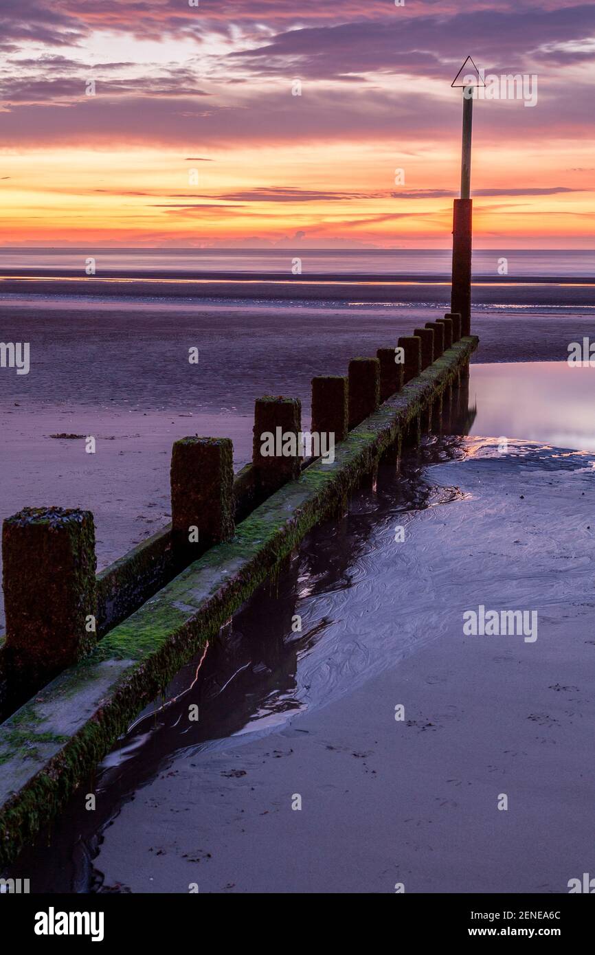 Sunset over Rhyl beach at low tide on the North Wales coast Stock Photo
