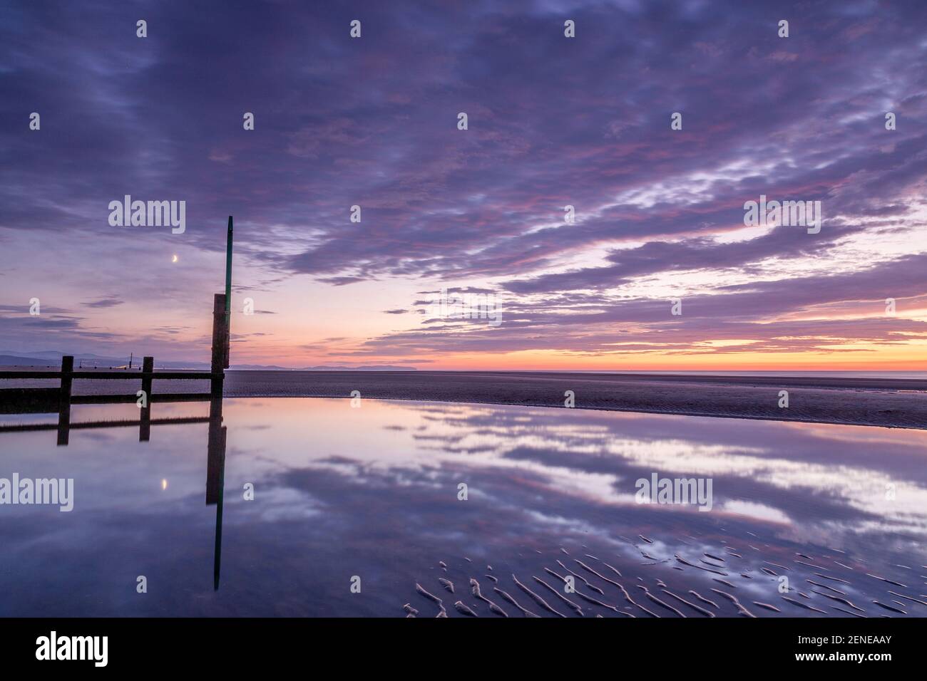 Sunset over Rhyl beach at low tide on the North Wales coast Stock Photo