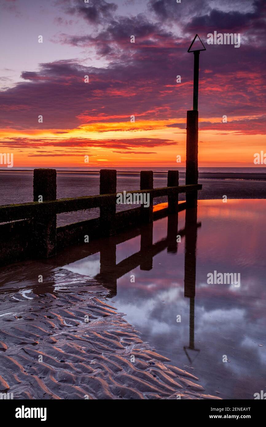 Sunset over Rhyl beach at low tide on the North Wales coast Stock Photo