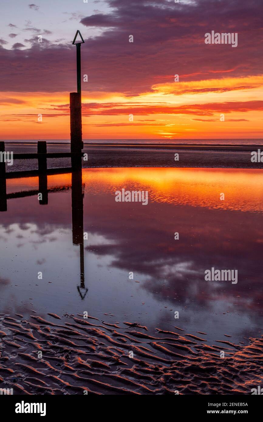 Sunset over Rhyl beach at low tide on the North Wales coast Stock Photo