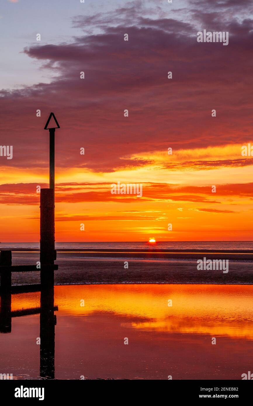 Sunset over Rhyl beach at low tide on the North Wales coast Stock Photo