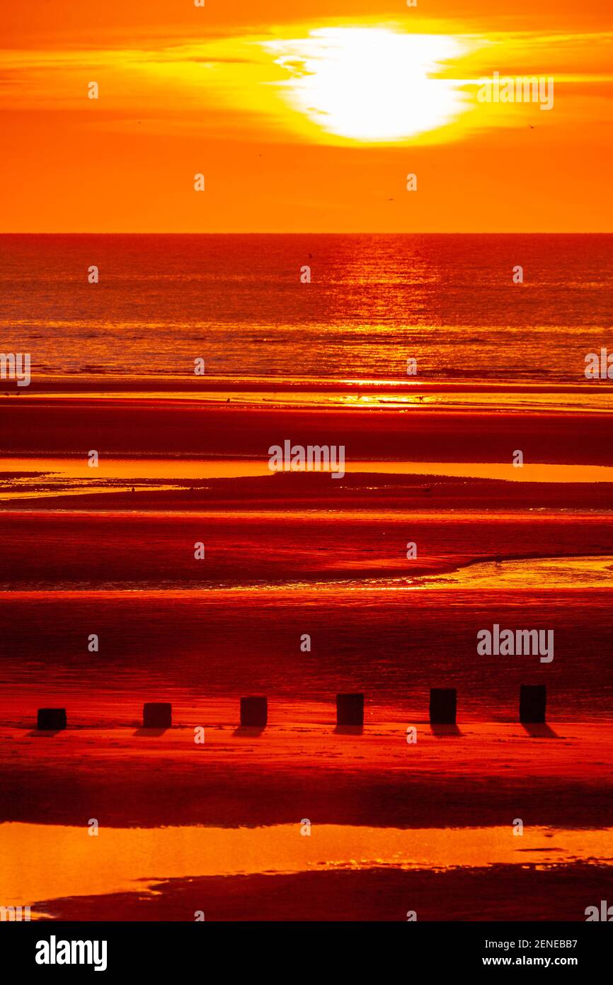 Sunset over Rhyl beach at low tide on the North Wales coast Stock Photo