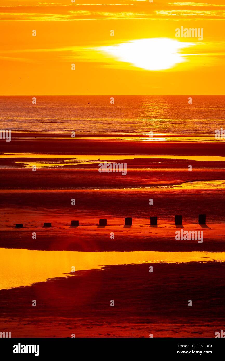 Sunset over Rhyl beach at low tide on the North Wales coast Stock Photo
