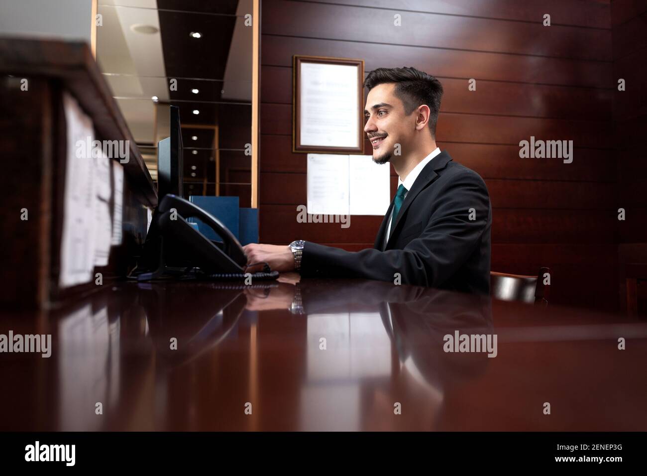 Young receptionist coordinating frontdesk activities, hotel service management Stock Photo Alamy