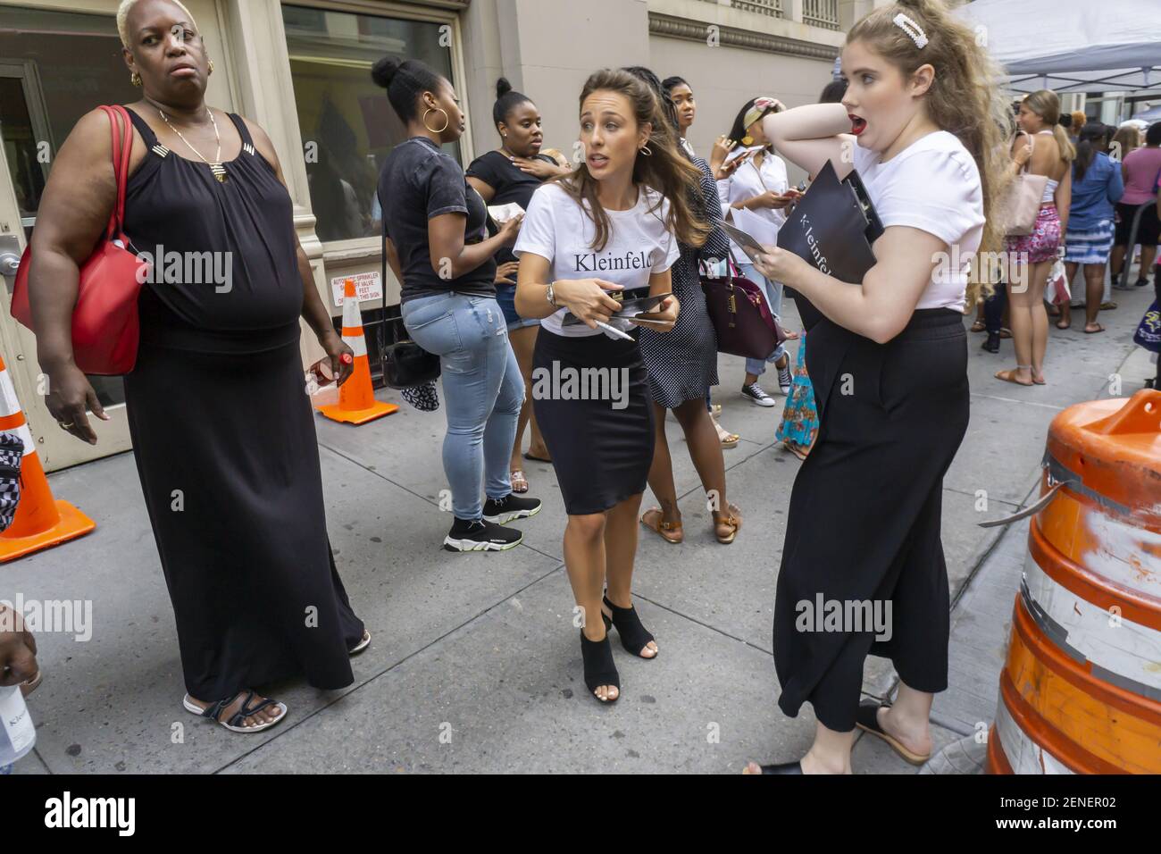 Workers from Kleinfeld organize the hundreds of brides bridesmaids and their mothers waiting in line as much as six hours to enter the Kleinfeld Bridal summer sample sale in New York on