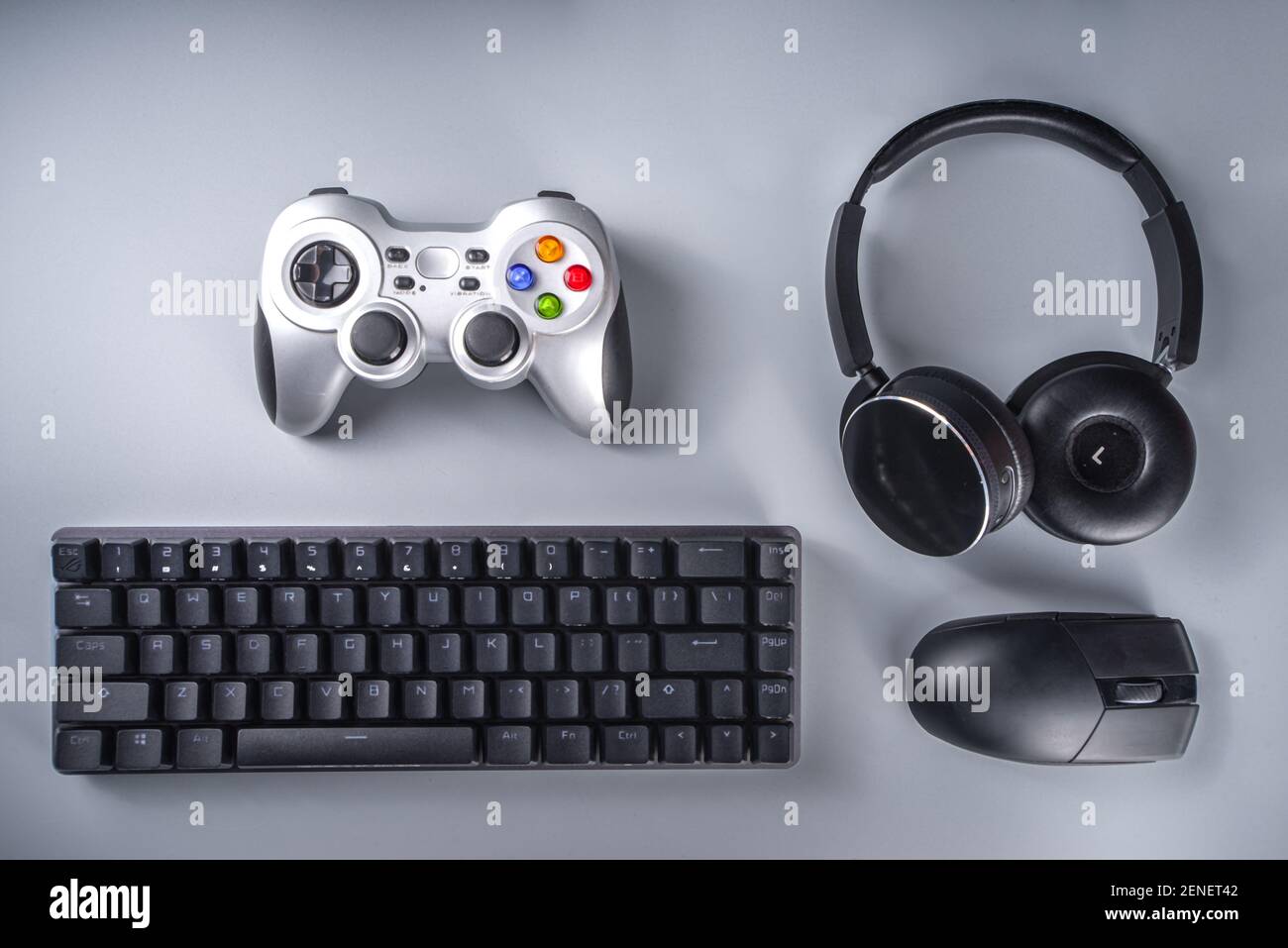 Gaming and gamer devices concept. Gamer work table space background, top  view. Keyboard, mouse, gamepad joystick, mouse pad and headphones. on grey  ta Stock Photo - Alamy