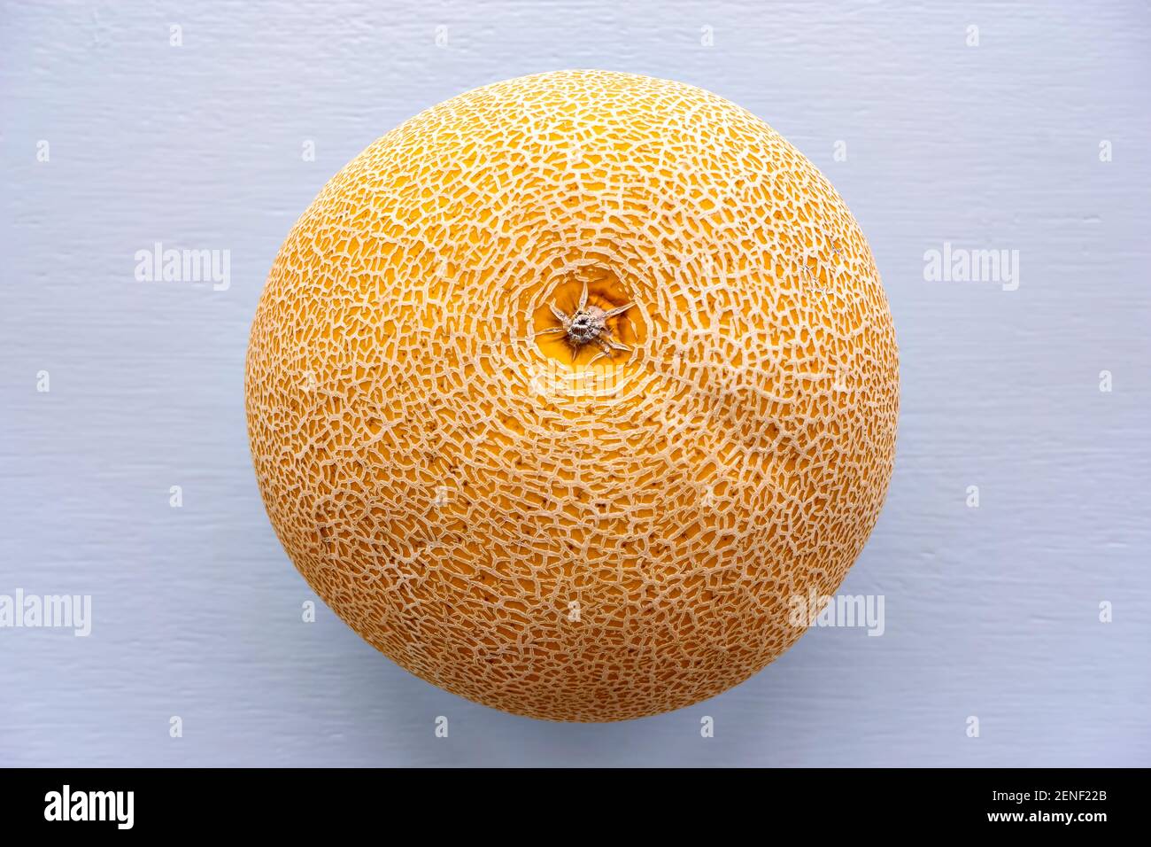 Top view image of honeydew melon with skin texture on a light background. Honeydew melon is the fruit of one cultivar group of the muskmelon. Stock Photo