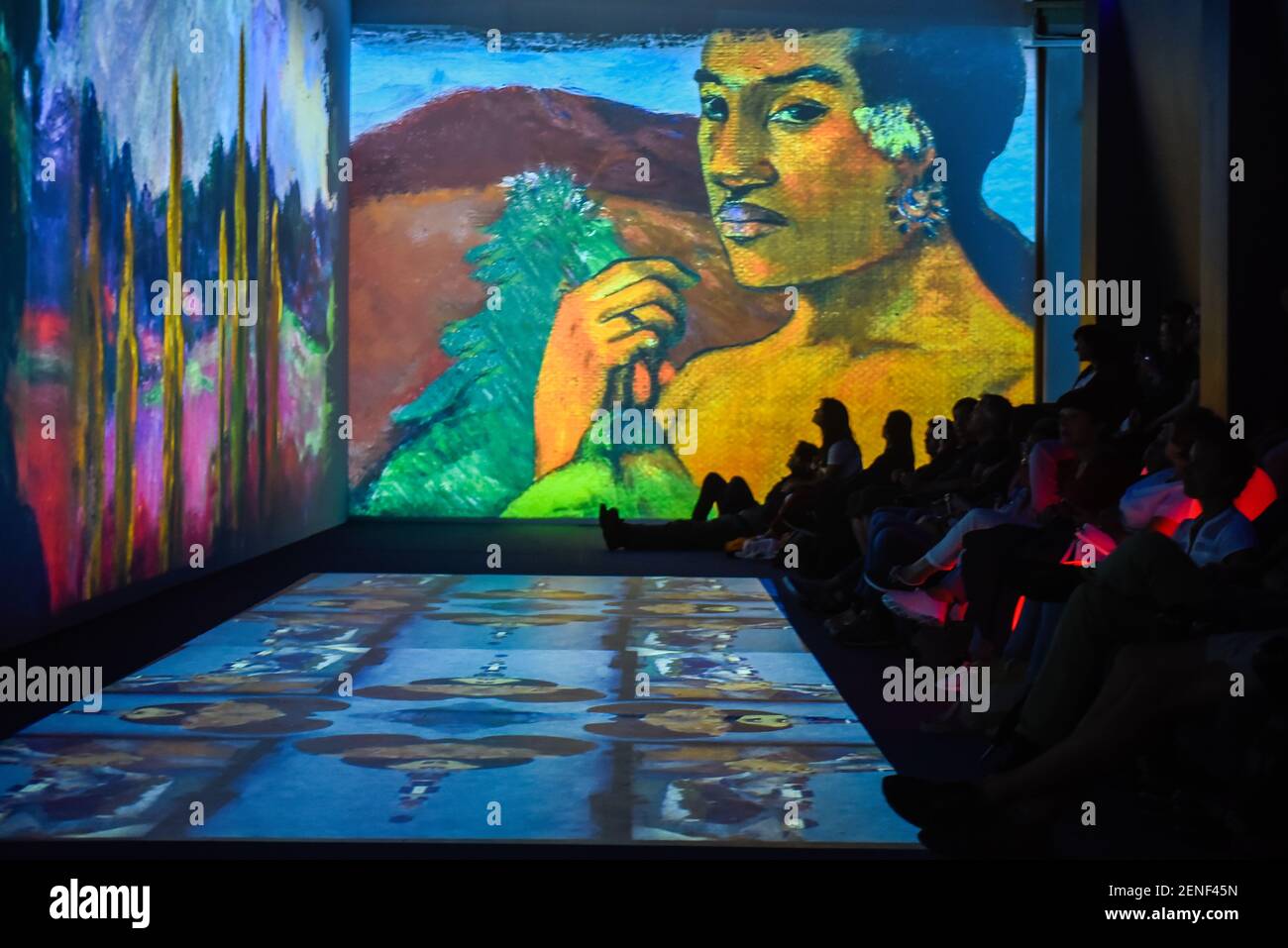 Visitors admire a multimedia projection in one of the exhibition rooms
