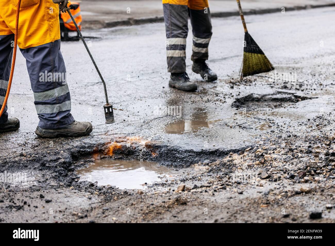 pothole repair - maintenance service workers working on the road Stock Photo